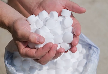 One of our plumbers holding water softener tablets.